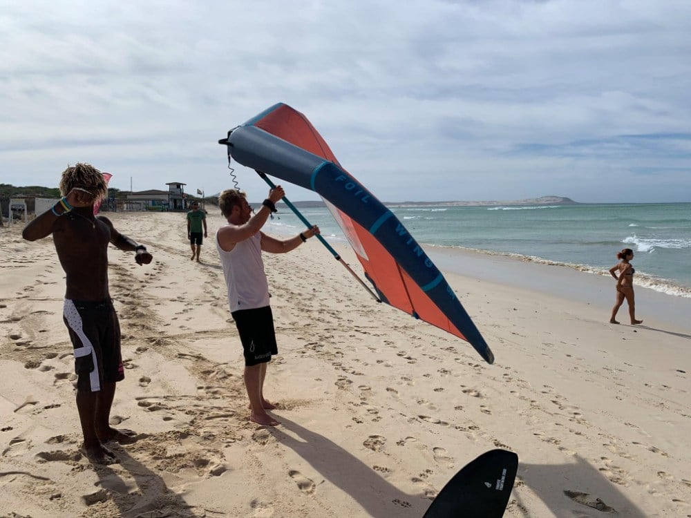 Holding the wing up on the beach to get a feel for the wind before going on the water
